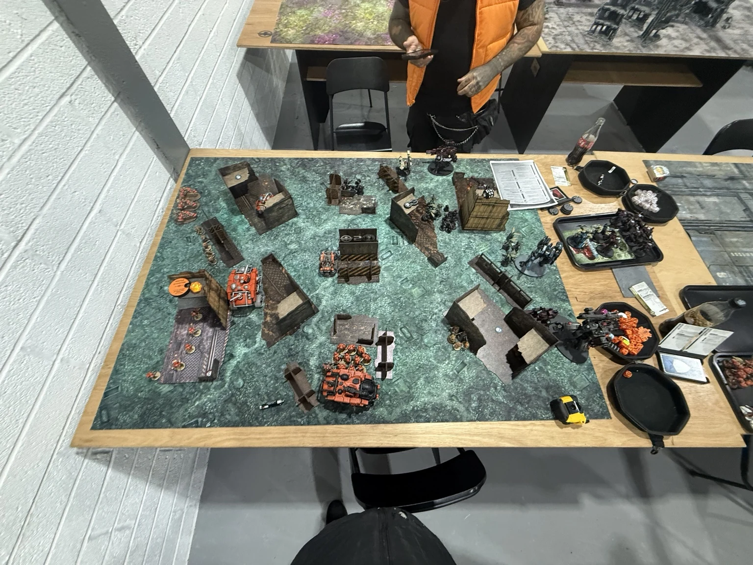 Orange Votann vehicles advancing around the left and central ruins